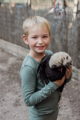 Boy smiles holding a chicken in the confident clover long sleeve pyjamas