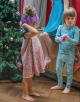 boy and girl wearing soft sensory friendly pyjamas at Christmas. The boy has a squishy toy in his hands