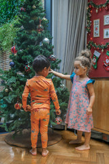 Two children decorating a Christmas tree wearing sensory-friendly clothing.