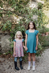 Two girls holding hands wearing sensory-friendly Bouncing Butterfly reversible dresses